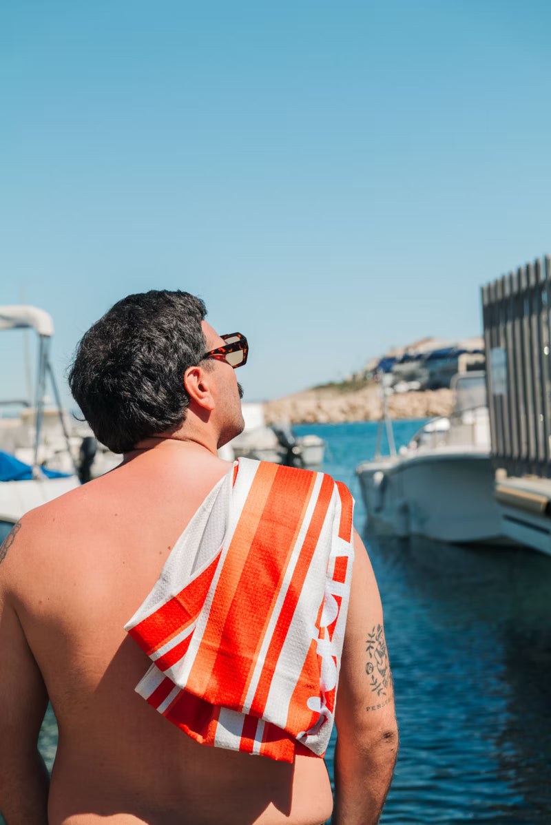 orange and white stripe towel over man shoulder 