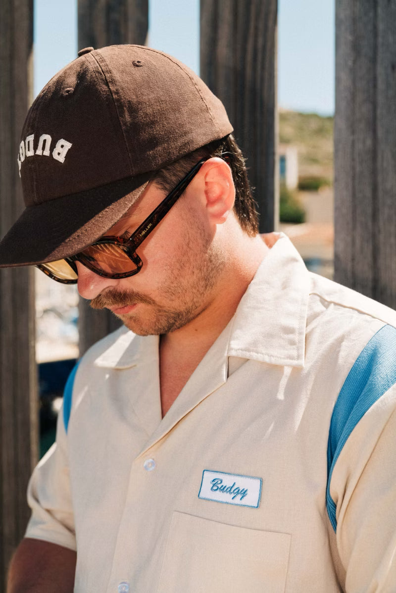 Brown hat with white text on a man 